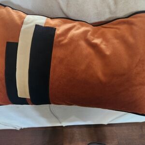 Decorative orange and black pillow cover.